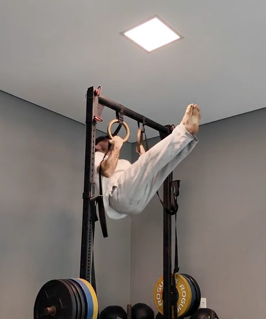 Tony nas argolas, sustentando o próprio corpo